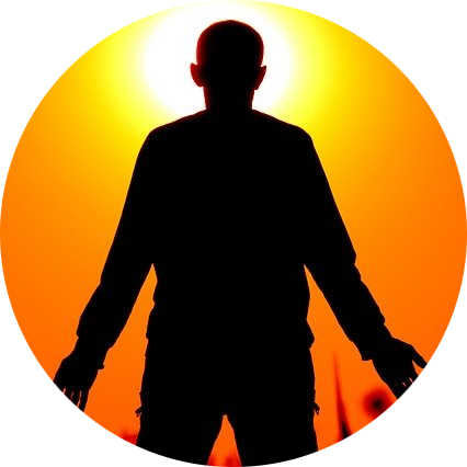 silhouette of man looking at a sunrise